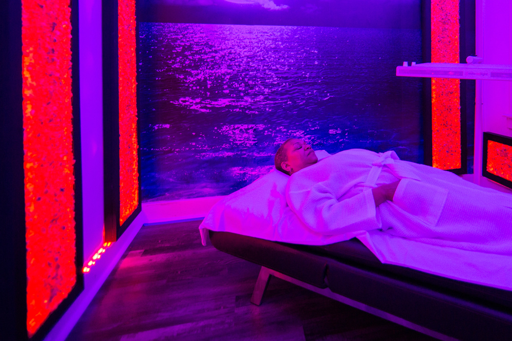 Woman laying down using red light therapy at Jardin's Magical Hands in Sacramento, CA.