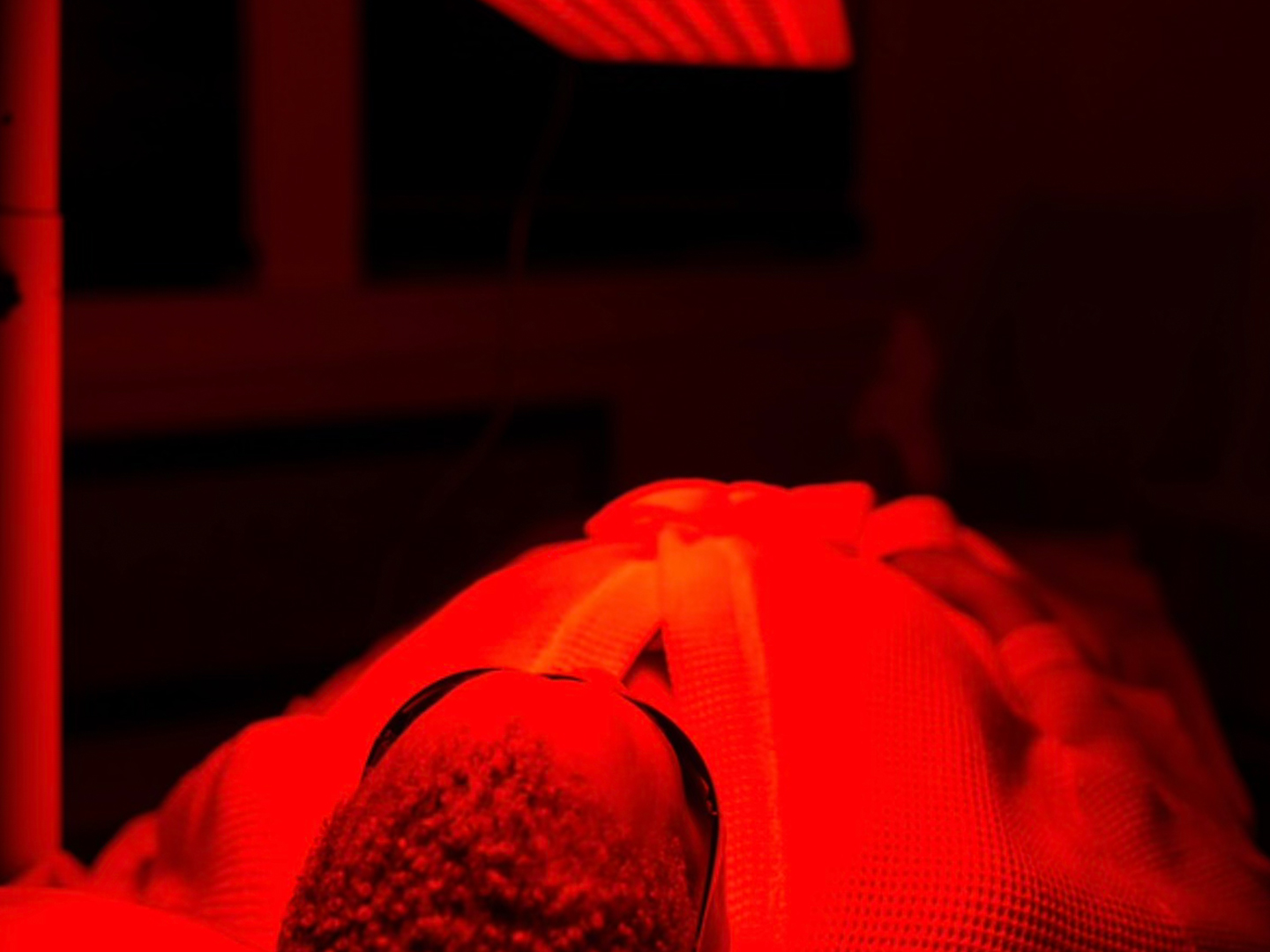 man laying using red light therapy at jardin's magical hands in sacramento, ca.